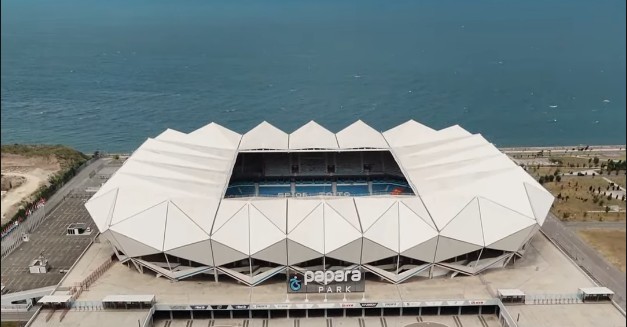 Deniz kenarında bulunan Trabzon Papara Park stadyumunun kuş bakışı drone görüntüsü ve çevre peyzajı.